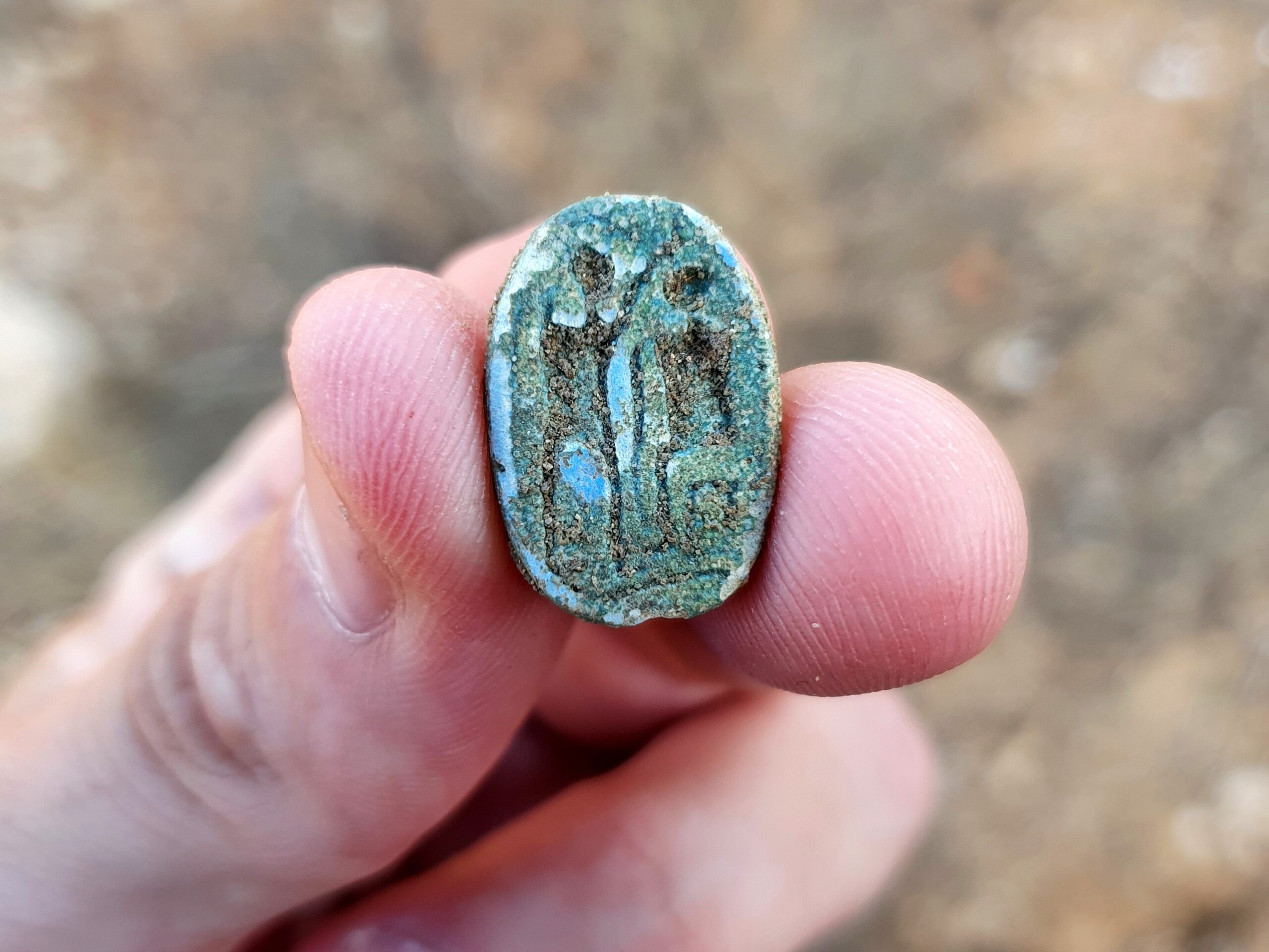 The scarab, showing a seated figure on the right and a standing figure with a raised arm on the left, possibly symbolizing the imparting of authority. Photo: Gilad Stern, Israel Antiquities Authority.